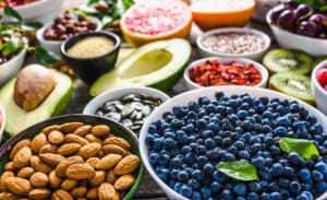 Table full of anti-stress superfoods like avocados, almonds, blueberries, and more